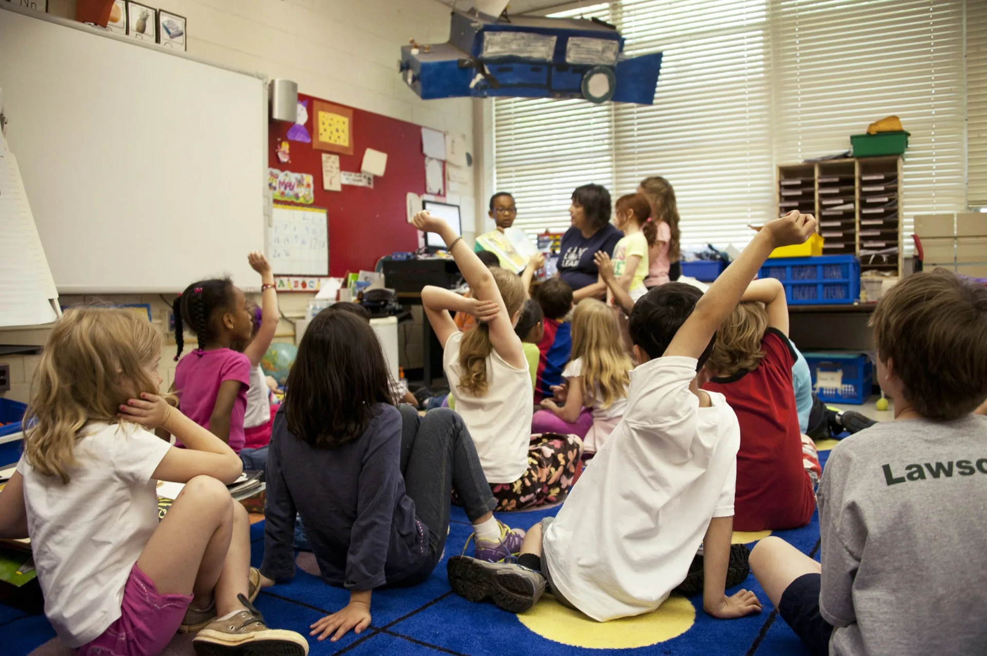 Students raising hands in classroom
